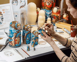 artist painting matryoshka doll face